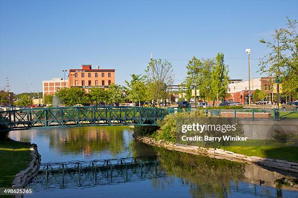 reflection of steel bridge in water in city park - kalamazoo stock pictures, royalty-free photos & images