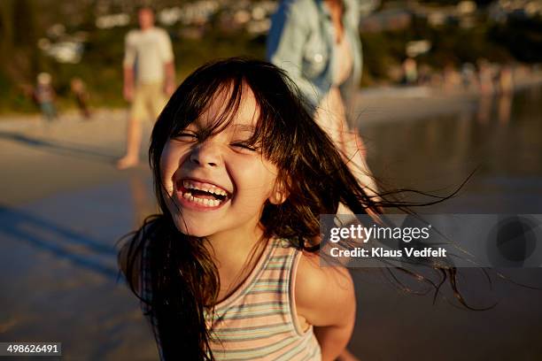 cute girl standing on beach and laughing - african girls on beach stockfoto's en -beelden