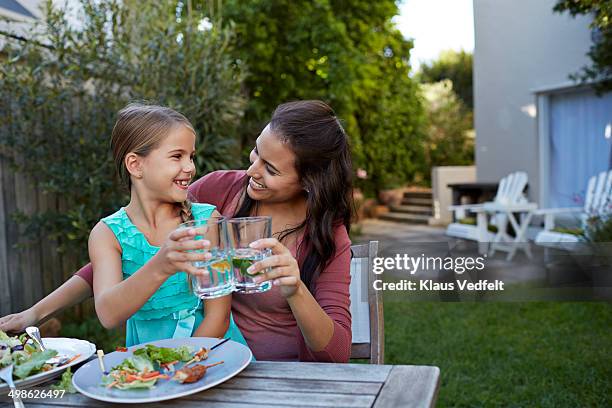 mother & daughter toasting in water with lime - african girl drinking water stockfoto's en -beelden