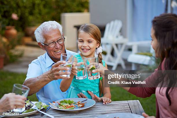 3 generations toasting in water with lime outside - water glasses ストックフォトと画像