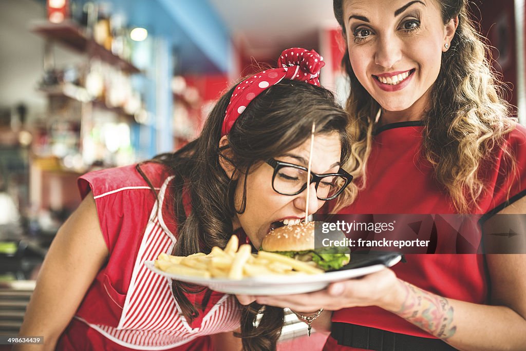 Empregada de Mesa serviço de um hamburger com as batatas fritas