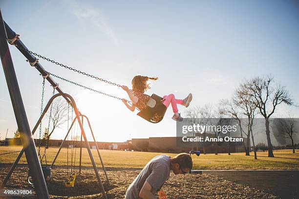 father giving daughter a underdog - schaukel stock-fotos und bilder