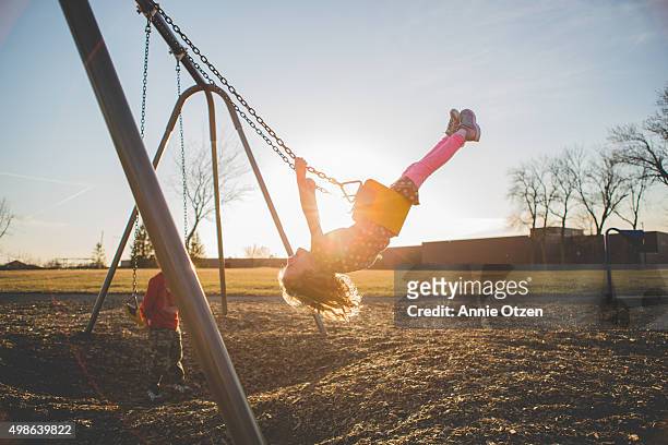 children playing on a swing set - skolgård bildbanksfoton och bilder