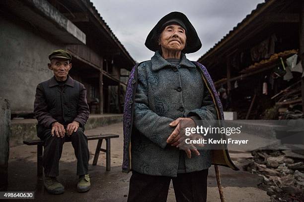 Chinese Yi minority villagers Qiu Kaibin left, and Mao Guixiang stand outside their farmhouse in the hills below the 7,556 m Mount Gongga, known in...