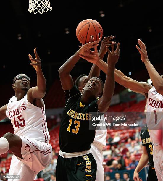 Joel Brokenbrough of the Cal State-Los Angeles Golden Eagles reaches for a loose ball against Valentine Izundu, Junior Longrus and Renard Suggs of...