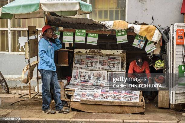 Man reads a newspaper carrying a headline about Pope Francis' visit to Africa in Nairobi on November 25, 2015. On the streets of the Kenyan capital...