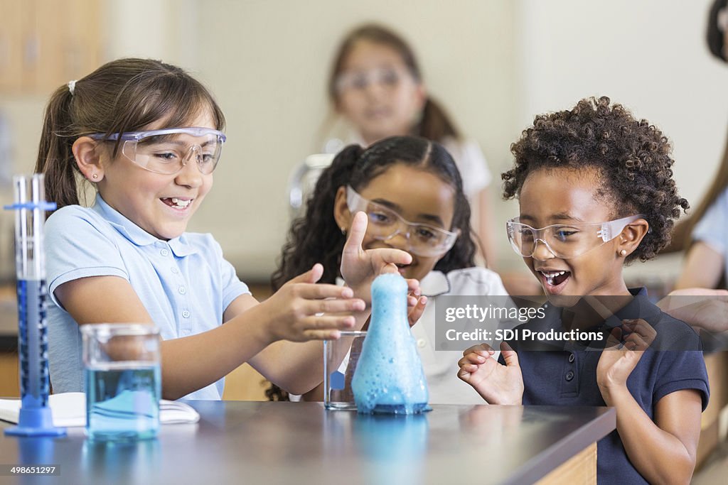 Felice ragazze utilizzando set di chimica insieme in classe di scienze elementari