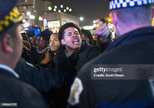 Demonstrators confront police during a protest following the release of a video showing Chicago Police officer Jason Van Dyke shooting and killing...