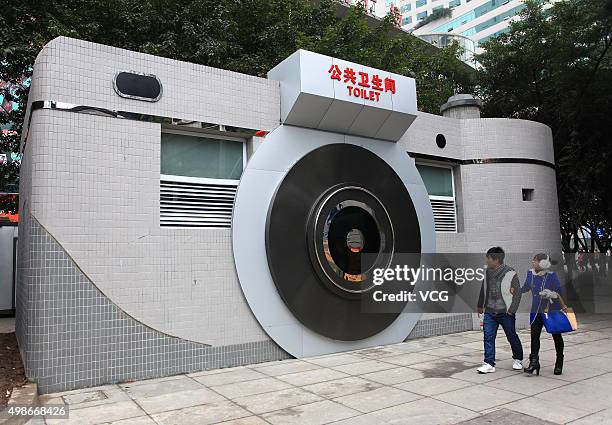 Two citizens watch a camera-shaped public toilet in Shiqiaopu Street on February 7, 2014 in Chonqging, China. The World Toilet Day falls in November...