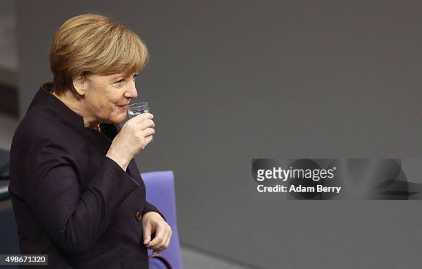 German Chancellor Angela Merkel has a drink of water as she arrives for a meeting of the Bundestag, the German federal parliament, as its members...