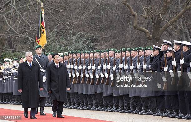 German President Joachim Gauck and Vietnam's President Truong Tan Sang review the honor guards during the welcoming ceremony for an official visit at...