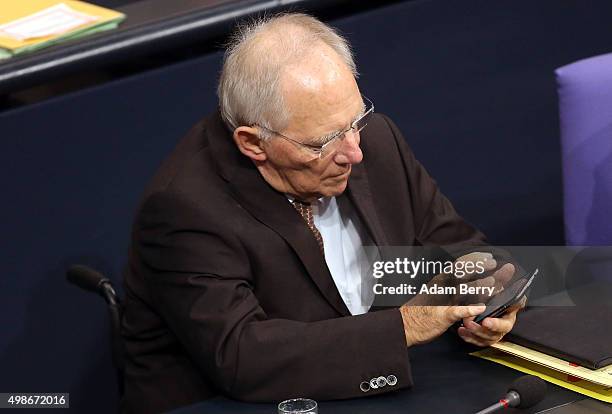 Finance Minister Wolfgang Schaeuble uses his mobile phone as he attends a meeting of the Bundestag, the German federal parliament, as its members...