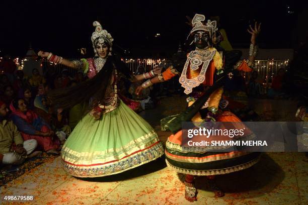 Indian dancers dressed as Hindu God Krishna and his consort Gopiyan are watched by devotees as they perform a dance or Raas Leela at The Chintpuri...