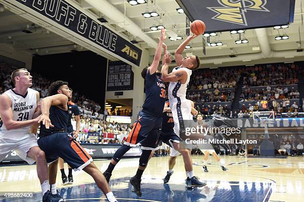 Joe McDonald of the George Washington Colonials drives to the basket over London Perrantes of the Virginia Cavaliersduring a college basketball game...