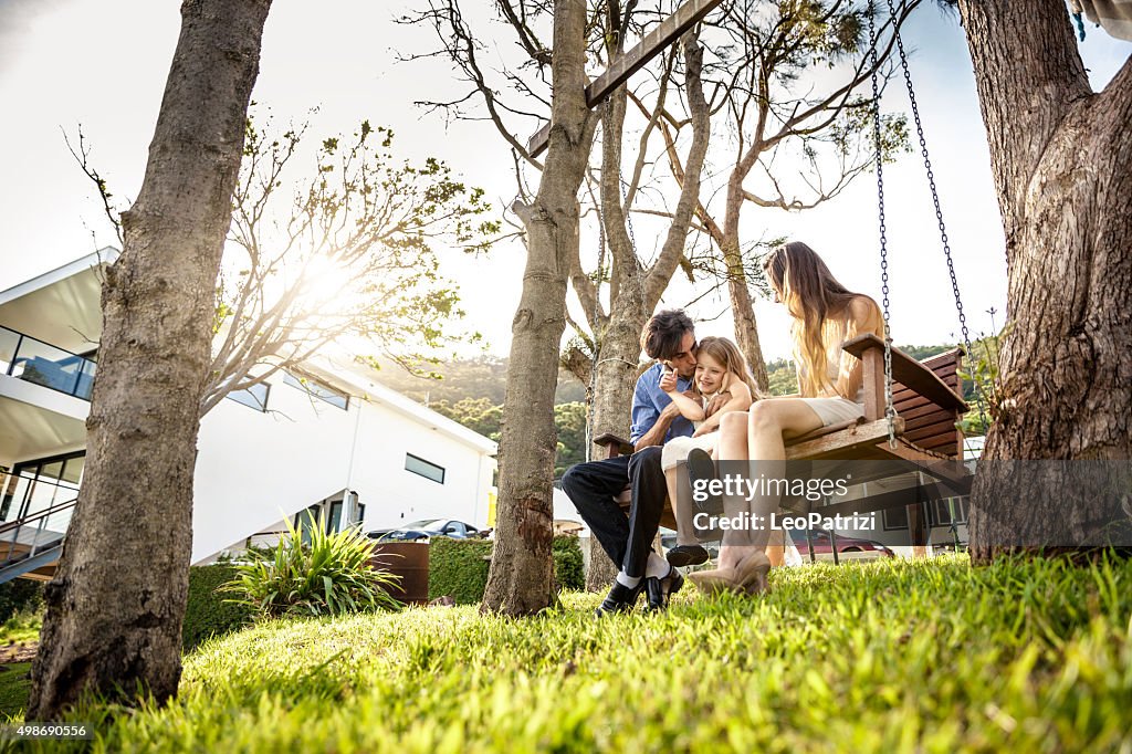 Family sitting on the backyard of their house in Australia