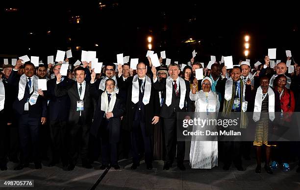 Prince Albert II of Monaco and delegates hold white peace cards after completing a Peace Walk from the Fairmont Hotel to the Grimaldi Forum ahead of...