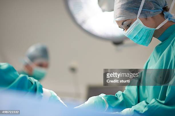 cirurgião feminino na mesa de operação - tratamento a laser imagens e fotografias de stock