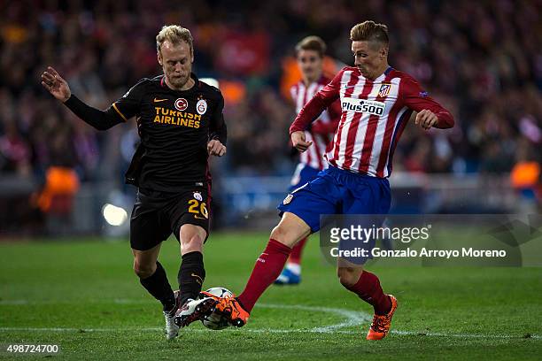 Semih Kaya of Galatasaray AS competes for the ball with Fernando Torres of Atletico de Madrid during the UEFA Champions League Group C match between...