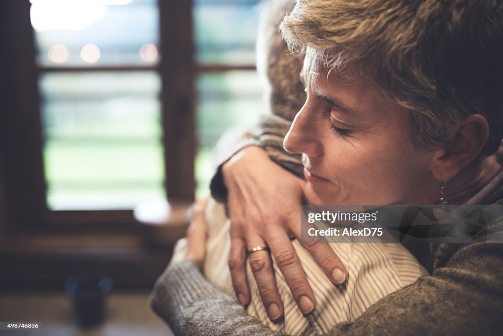 Senior couple embrace in kitchen