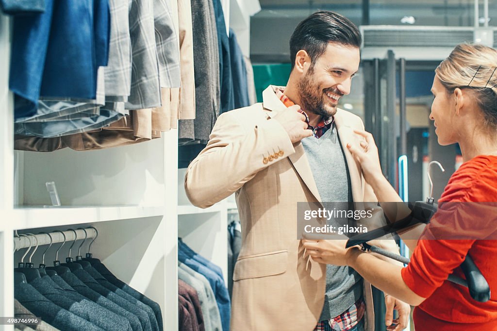 Couple buying clothes at department store.