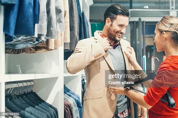 couple buying clothes at department store. - couple shopping in shopping mall stock pictures, royalty-free photos & images