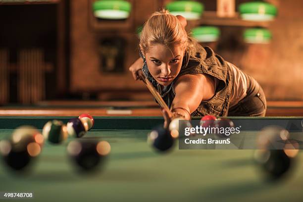 jovem mulher jogando sinuca em um pub. - snooker - fotografias e filmes do acervo