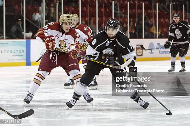 Yan Pavel Laplante of the Gatineau Olympiques controls the puck as Antoine Morand of the Acadie-Bathurst Titan defends on November 25, 2015 at Robert...