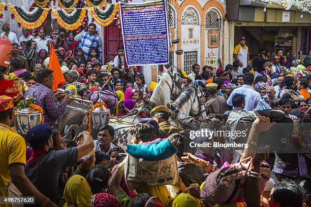 Devotees on their way to bath in Pushkar Lake merge with a procession, showcasing artists and children dressed as various Gods and Godesses, at a...