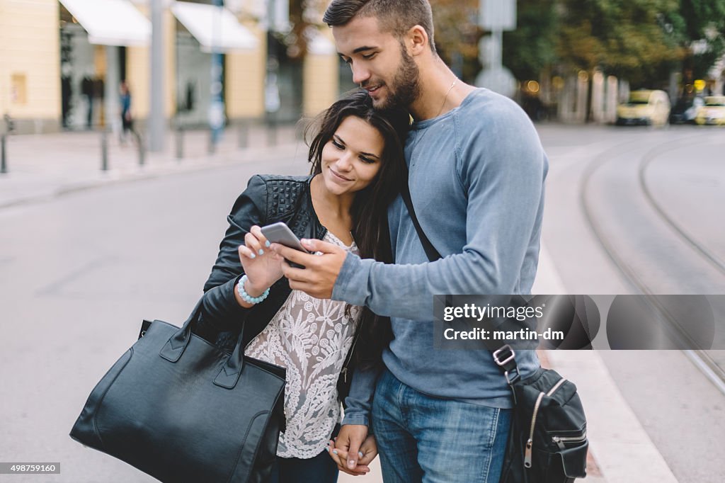 Coppia in città utilizzando smartphone