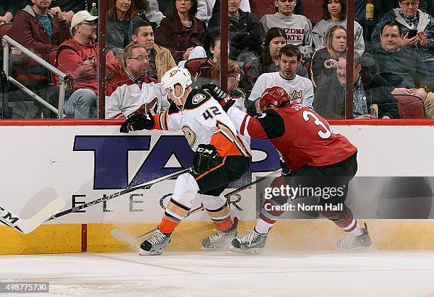 Josh Manson of the Anaheim Ducks and Dustin Jeffrey of the Arizona Coyotes battle for the puck along the boards during the first period at Gila River...