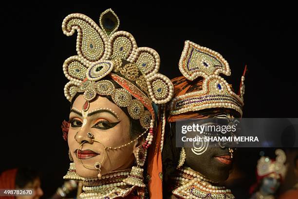Indian dancers dressed as Hindu God Krishna and his consort Gopiyan are watched by devotees as they perform a dance or Raas Leela at The Chintpuri...