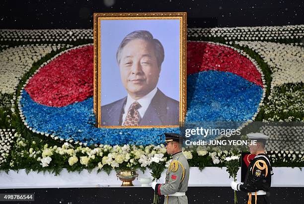 South Korean honour guards hold flowers in front of a portrait of the late former South Korean president Kim Young-Sam during a state funeral...