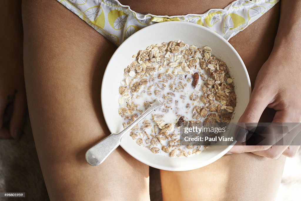 Closeup of bowl of muesli on womans' lap