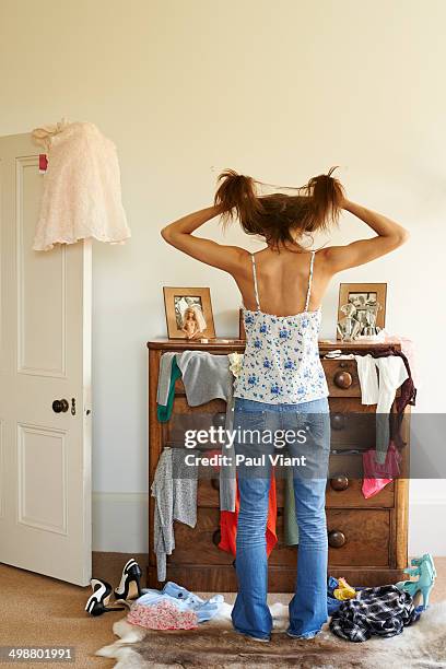 young woman standing by messy chest of drawers - chest of drawers 個照片及圖片檔