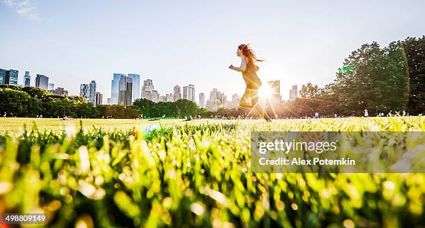 mädchen verläuft vor der skyline von manhattan im central park - city park stock-fotos und bilder