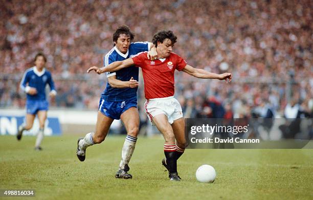 Manchester United defender Kevin Moran is challenged by Michael Robinson of Brighton during the 1983 FA Cup Final between Manchester United and...