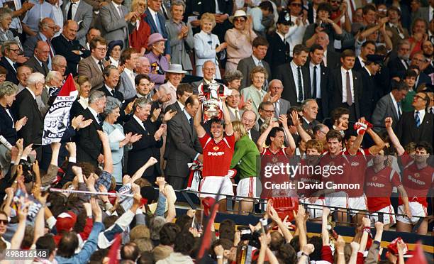 Manchester United captain Bryan Robson holds aloft the trophy after the 1985 FA Cup Final between Manchester United and Everton at Wembley Stadium on...