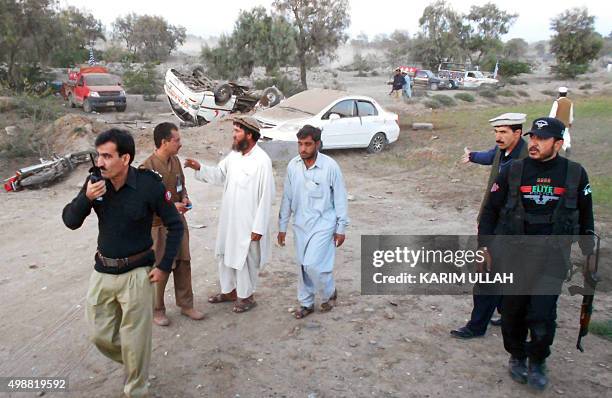 Pakistani security officials and residents gather at the site after a bomb blast in Bannu on November 26, 2015. At least two people were killed when...