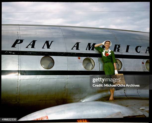 Model poses as a passenger walking off the Pan American Clipper "Challenge" Lockheed 1049 airliner circa 1947.