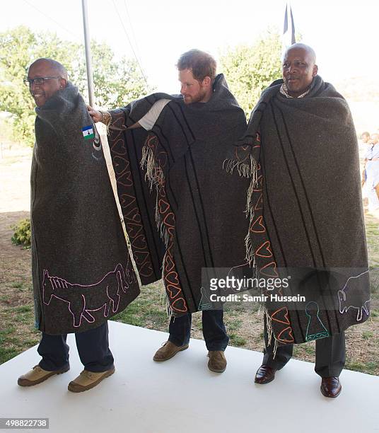 Prince Seeiso of Lesotho, Prince Harry and King Letsie III of Lesotho wear shawls given to them as a gift as they attend the opening of Sentebale's...