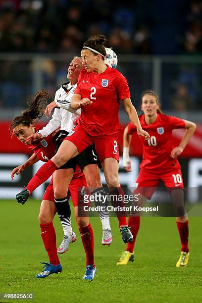 Fara Williams of England, Mandy Islacker of Germany and Lucy Bronze of England go up for a header during the Women's International Friendly match...