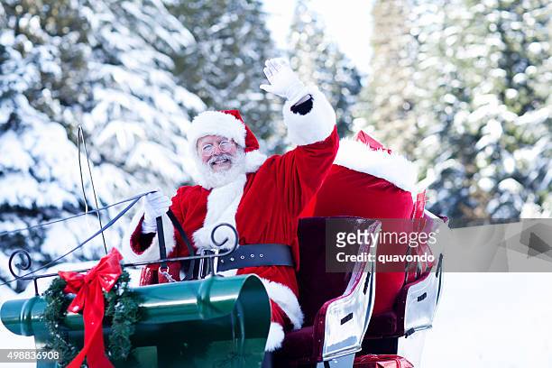 santa claus sitting in his sleigh waving - santa waving stock pictures, royalty-free photos & images