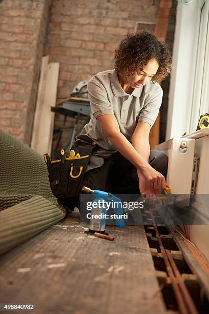 female plumber radiator installation - bijstellen stockfoto's en -beelden