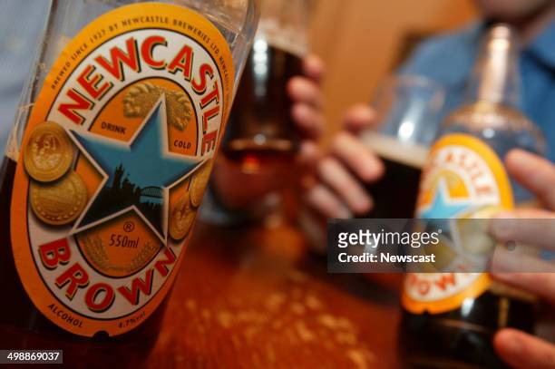 Two men drinking Newcastle Brown Ale; a Scottish and Newcastle brand.