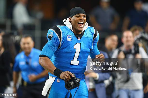 Cam Newton of the Carolina Panthers runs with a camera after a 33-14 win against the Dallas Cowboys at AT&T Stadium on November 26, 2015 in...