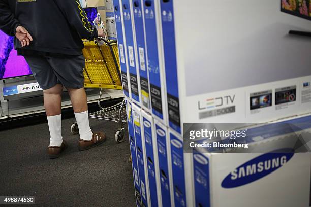 Customer with a shopping cart stands near Samsung Electronics Co. Televisions at a Best Buy Co. Store ahead of Black Friday in Chesapeake, Virginia,...