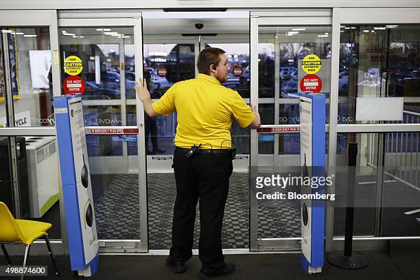 An employee prepares to open the entrance doors to a Best Buy Co. Store ahead of Black Friday in Chesapeake, Virginia, U.S., on Thursday, Nov. 26,...