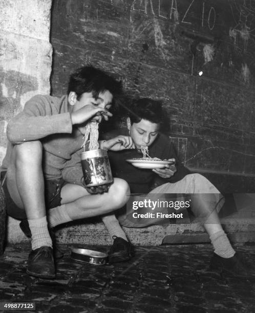 Young eating on the street Spaghetti, in Rome 1953.