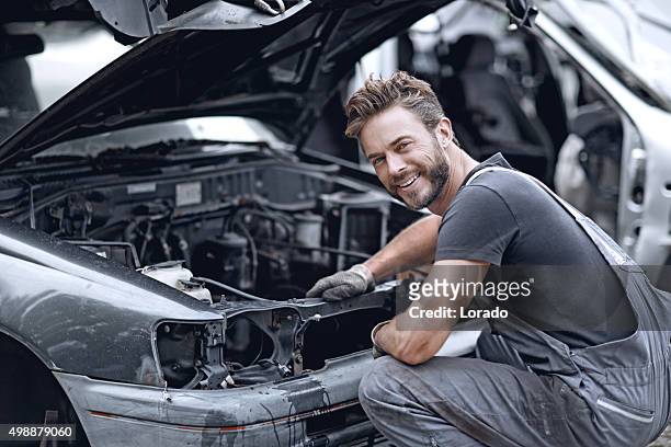 männliche mechaniker reparieren auto - autoschrottplatz stock-fotos und bilder