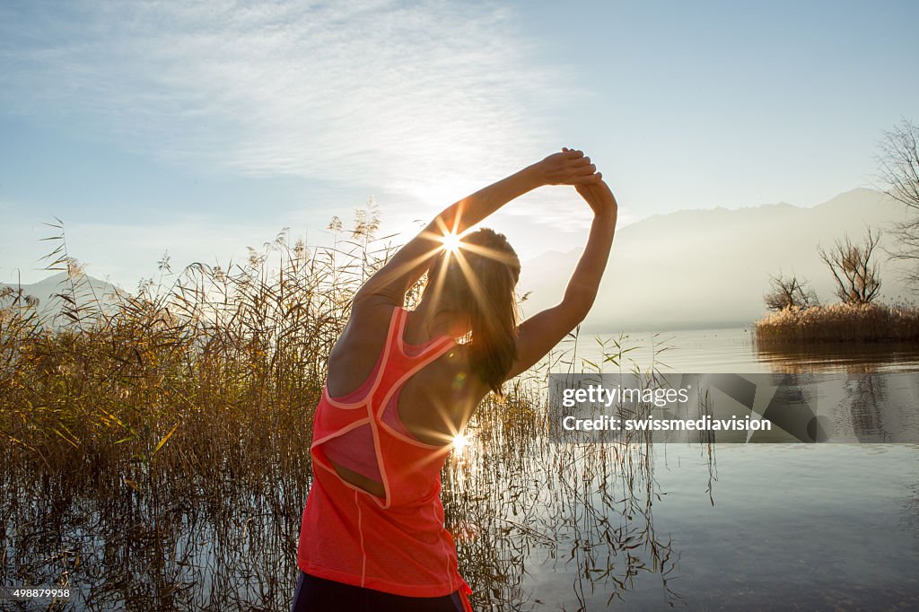 Young and sporty woman stretching after jogging outdoors